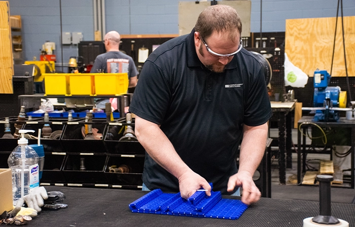 Motion Conveyance Solutions technician working while wearing personal protective gear in facility