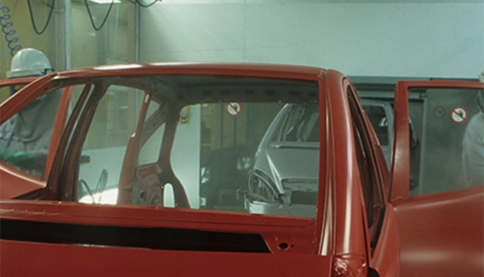 Close-up of red car frame in an auto assembly line within facility