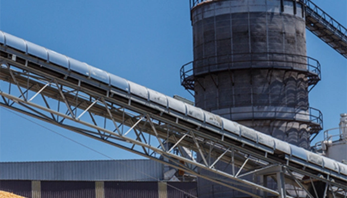 Close-up of conveyor belting on site with blue skies in the background