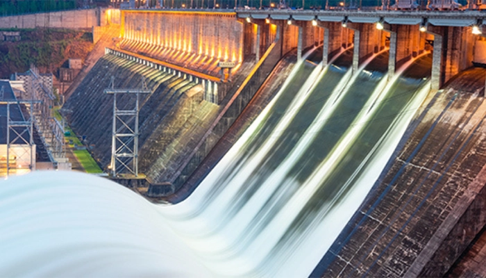 Night time view of a hydroelectric dam with water discharge through locks