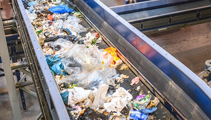 Trash moving through recycling facility on a conveyor belt