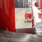 Interior of Motion Distribution Center with red plastic totes carrying products moving along conveyor