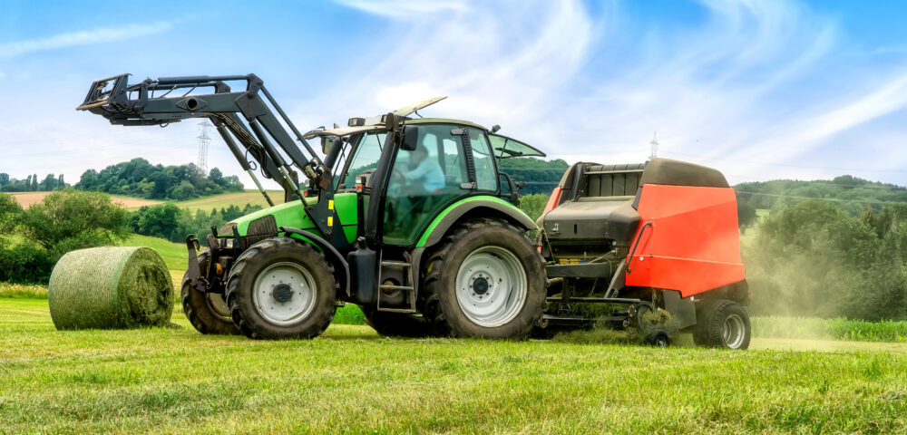 Big baler with film wrapper in use for grass silage preparation