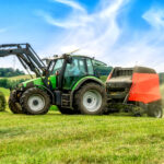 Big baler with film wrapper in use for grass silage preparation