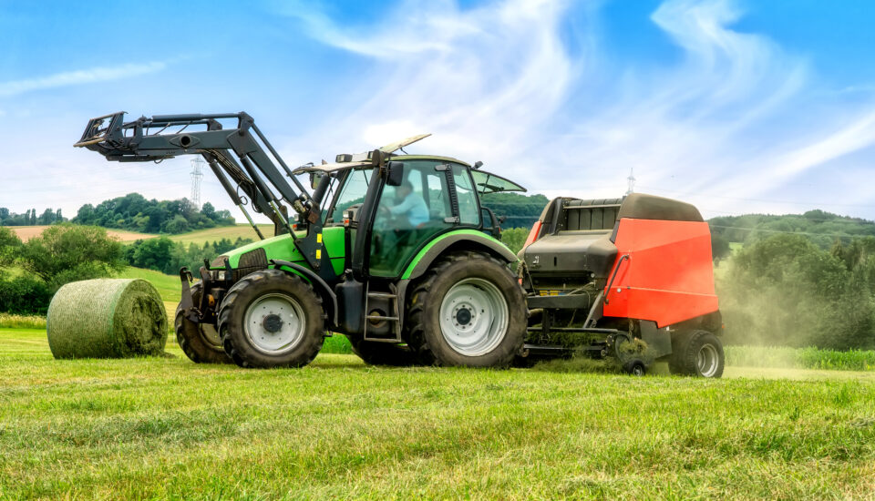 Big baler with film wrapper in use for grass silage preparation